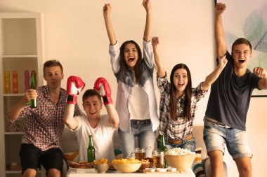 Genç hayranlar TV 'de bira ve atıştırmalıklarla boks izliyorlar