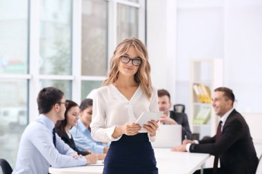 Ofiste meslektaşları olan bir iş kadını.