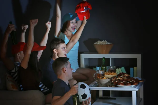 若いファンは夜遅くにテレビでサッカーの試合を見てビールや軽食 — ストック写真