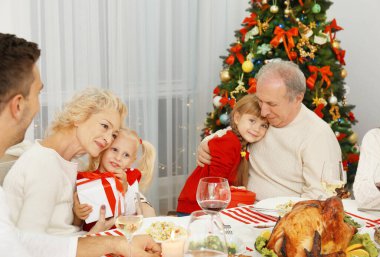 Mutlu aile Noel yemeğini oturma odasında yiyor.