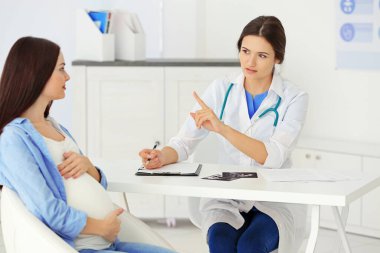 Genç hamile kadın doktoru ziyaret ediyor.