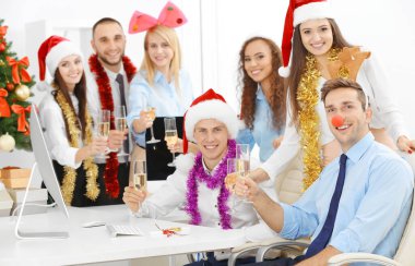 Noel 'i ofis partisinde şampanya kadehleriyle kutlayan gençler.