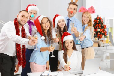 Noel 'i ofis partisinde şampanya kadehleriyle kutlayan gençler.