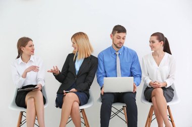 Ofiste iş görüşmesini bekleyen bir grup insan.