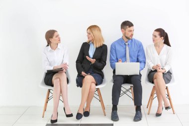 Ofiste iş görüşmesini bekleyen bir grup insan.