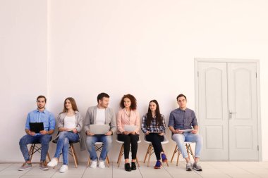 Ofiste iş görüşmesini bekleyen bir grup insan.