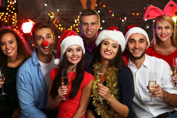 Young people with glasses of champagne at Christmas party