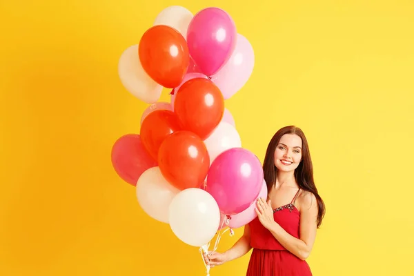 Sarı Arka Planda Hava Balonları Olan Güzel Genç Bir Kadın — Stok fotoğraf