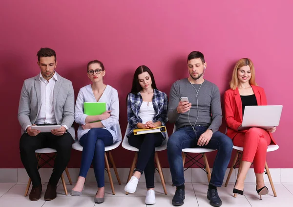 色の背景で仕事のインタビューを待っている人々のグループ — ストック写真