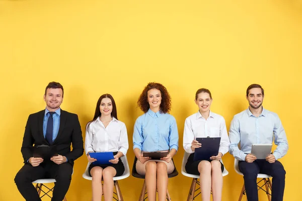 黄色の壁の背景に仕事のインタビューを待っている人々のグループ — ストック写真