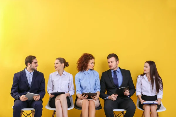 Gruppe Von Menschen Wartet Auf Vorstellungsgespräch Auf Gelbem Wandhintergrund — Stockfoto