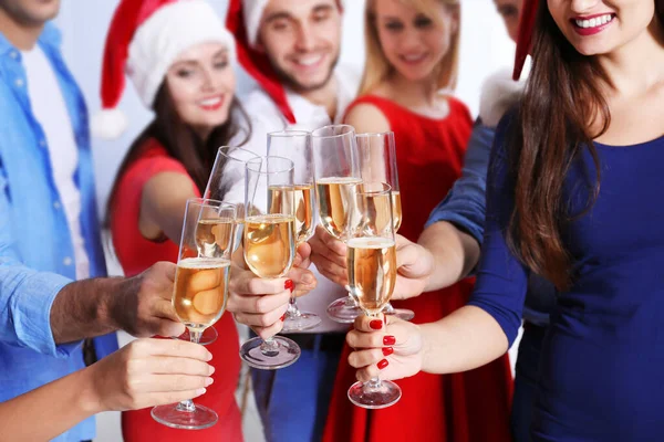 在公司聚会上庆祝圣诞节的年轻人喝香槟 图库图片