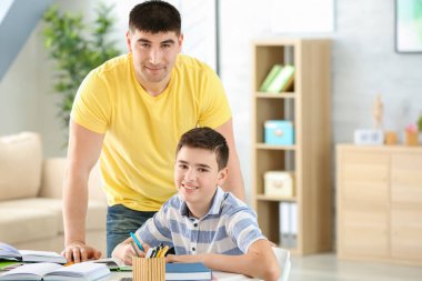 Baba ve oğul ev ödevlerini evde yapıyorlar.