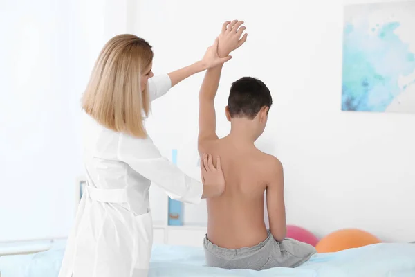 姿勢の概念が間違っている 理学療法士は少年の背中を検査し修正する — ストック写真
