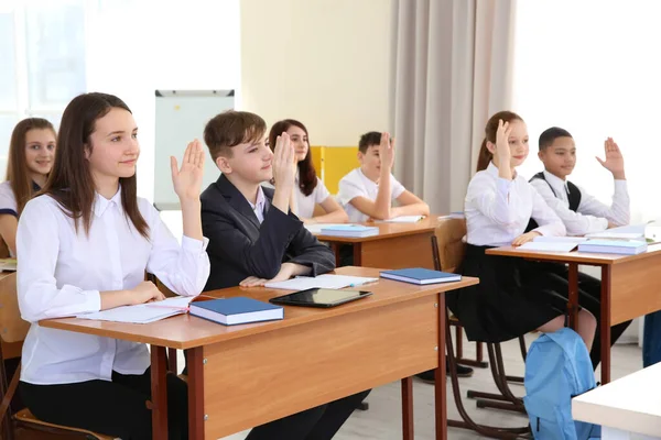 Pupils Raising Hands Answer Classroom — Stock Photo, Image