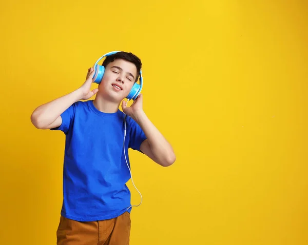 十代の若者たちとともにヘッドフォン色の背景で音楽を聴く — ストック写真