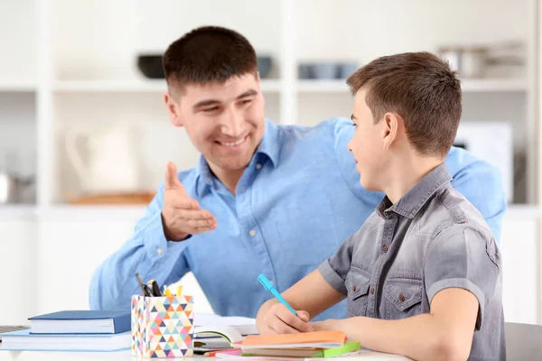 Baba ve oğul ev ödevlerini evde yapıyorlar.