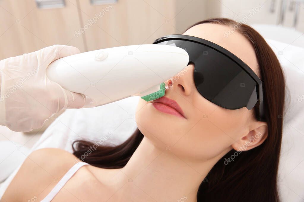 Beautiful woman getting laser epilation in beauty salon