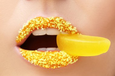 Yaratıcı makyajı olan genç ve güzel bir kadın ağzına reçel koyuyor.