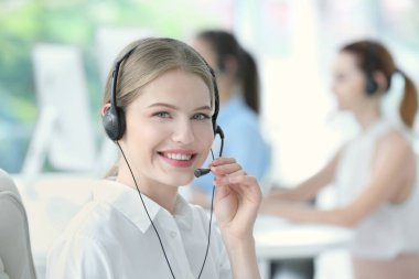 Genç bayan teknik destek memuru ofiste çalışıyor.