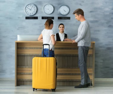 Oteldeki resepsiyonda oturan genç çift.