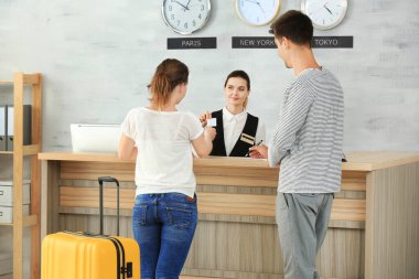 Oteldeki resepsiyonda oturan genç çift.