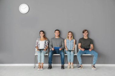 Bir grup insan koltuklarda iş görüşmesi için bekliyor.