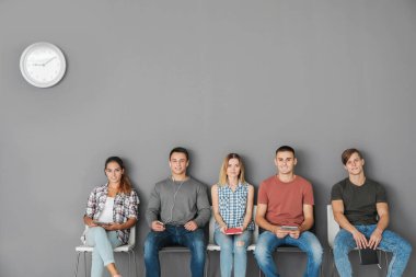 Bir grup insan koltuklarda iş görüşmesi için bekliyor.