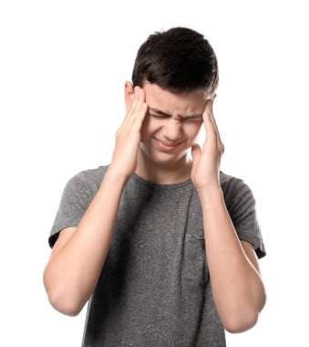 Beyaz arka planda baş ağrısı çeken genç bir çocuk.