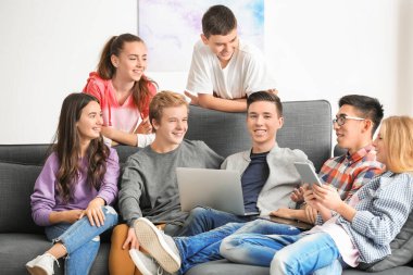 Modern cihazlarla kapalı koltukta oturan genç grup