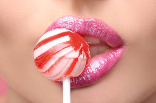 Губы красивой молодой женщины с леденцом, крупным планом
