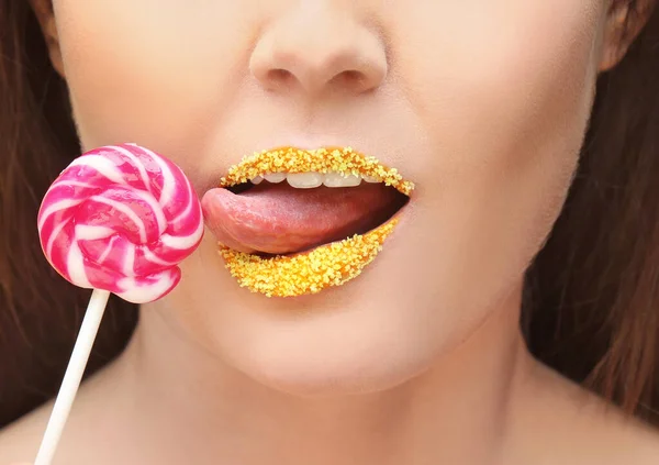 女人抱着棒棒糖靠近嘴唇与创造性的化妆 — 图库照片
