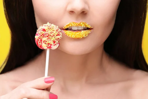 有创意的化妆和棒棒糖的漂亮年轻女子的唇 — 图库照片