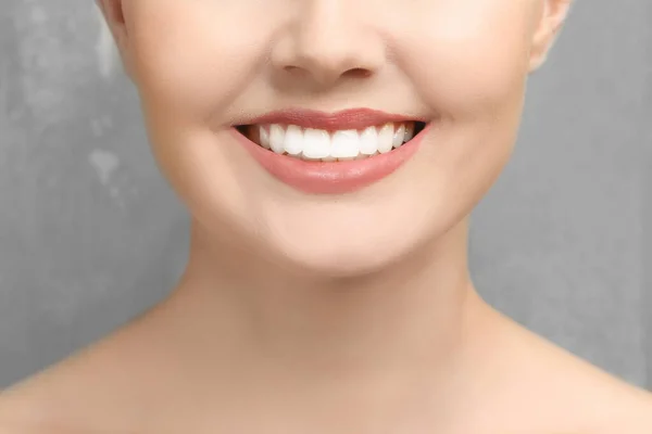 灰色の背景に健康な歯を持つ若い女性 クローズアップ — ストック写真