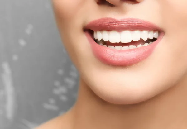 灰色の背景で笑って健康な歯を持つ若い女性 クローズアップ — ストック写真