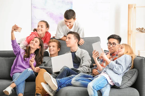 Skupina Teenagerů Moderní Zařízení Selfie Zatímco Sedí Gauči Doma — Stock fotografie