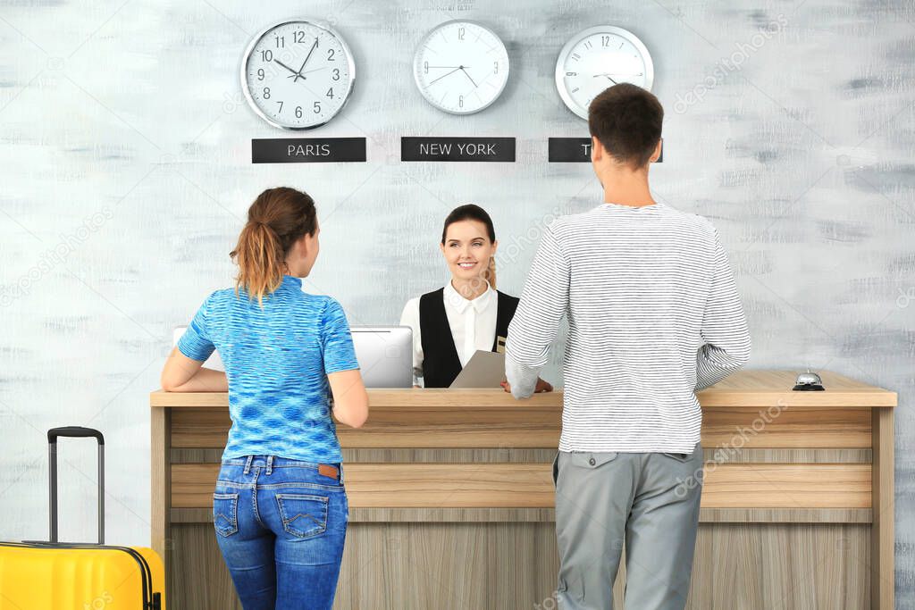 Young couple at reception desk in hotel