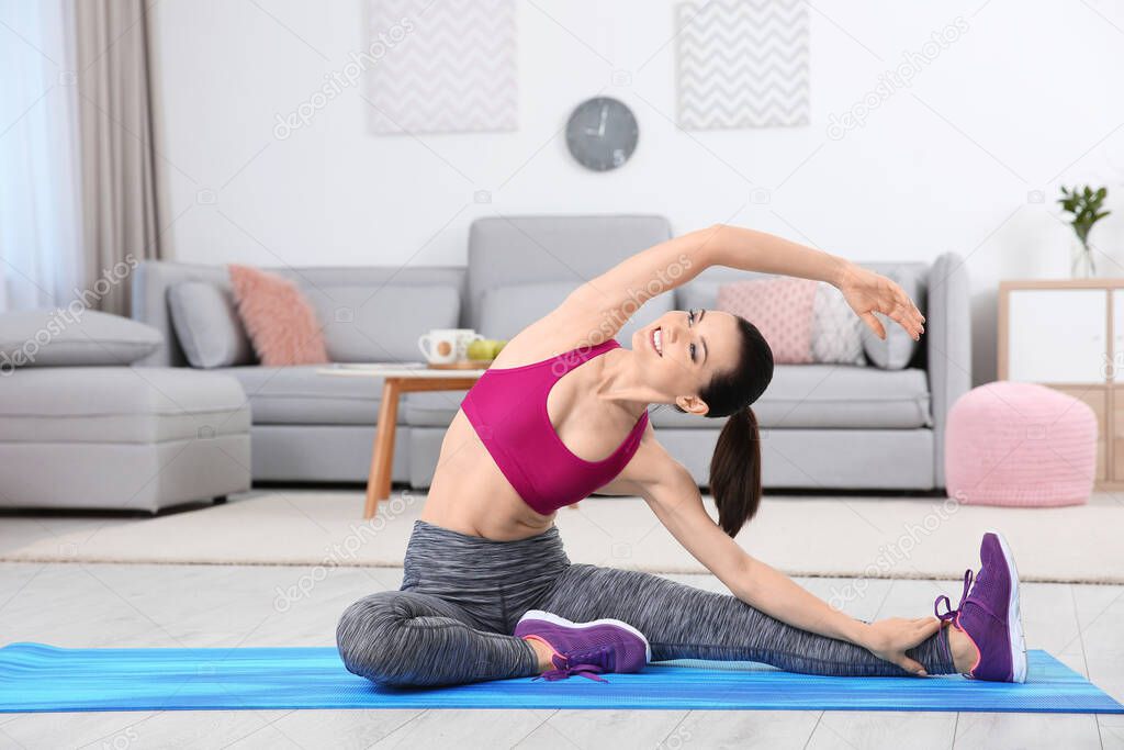 Young sporty woman doing exercise at home