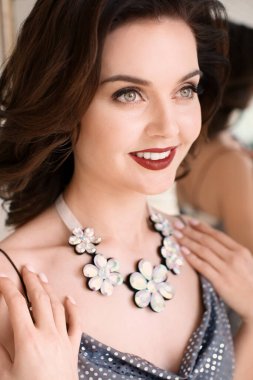 Partide zarif mücevherleri olan güzel bir kadın.