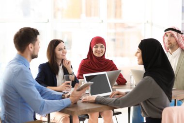 Ofis çalışanları ve Müslüman iş arkadaşları ofiste iş toplantısı yapıyorlar.