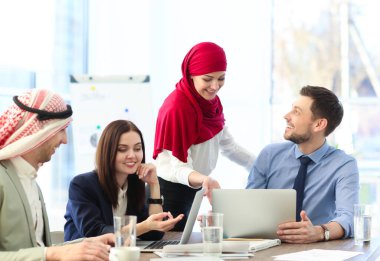 Ofis çalışanları ve Müslüman iş arkadaşları ofiste iş toplantısı yapıyorlar.