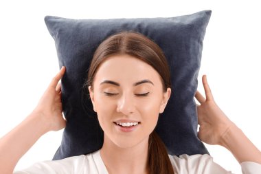 Beyaz arka planda yastığı olan uykulu genç kadın.