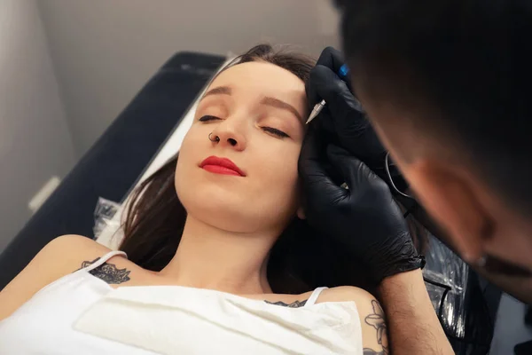 专业纹身大师在沙龙的眉毛上涂永久化妆品 — 图库照片