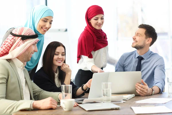 オフィスの従業員とイスラム教徒の同僚はオフィスでビジネスミーティングをしています — ストック写真