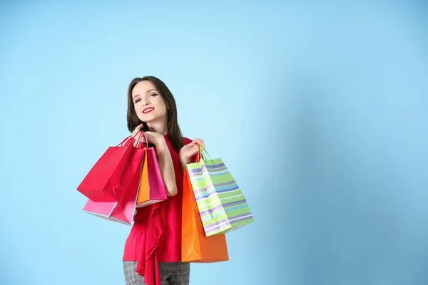 Mooie Jonge Vrouw Met Boodschappentassen Kleur Achtergrond — Stockfoto