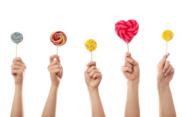 Beyaz arka planda tatlı lolipopları olan eller