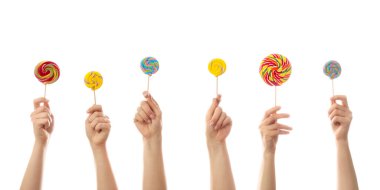 Beyaz arka planda tatlı lolipopları olan eller