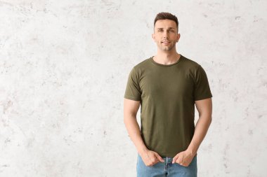 Hafif arka planda şık tişörtlü bir adam.