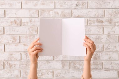 Açık arkaplanda boş kartı olan kadın elleri