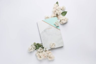 Beyaz arka planda güzel leylak çiçekleri ve defter